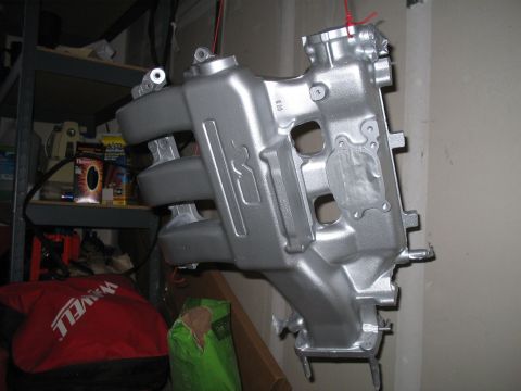 1995 Ford Probe - Intake manifold, likely for a car engine, painted silver and suspended for display or work.