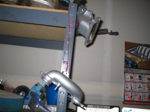 1995 Ford Probe - A metal engine part is suspended by red wire against a wall with a calendar in the background.
