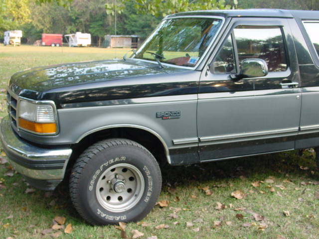 1993 Ford Bronco, two-tone grey and black paint, parked on grass