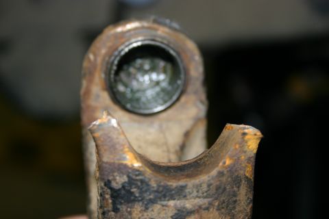 2003 Jeep TJ - This heavily rusted metal component shows signs of damage and wear, with grease visible inside a hollow section.