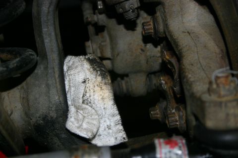 2003 Jeep TJ - A greasy rag rests on rusty suspension components, obscuring a portion of the machinery.