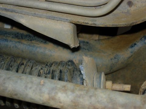 1995 Ford Bronco - Damaged suspension component, likely requiring replacement.