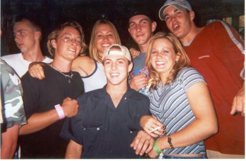 2004 Ford Taurus - A group of friends gather for a photo, with several individuals smiling and one person holding a cigarette.