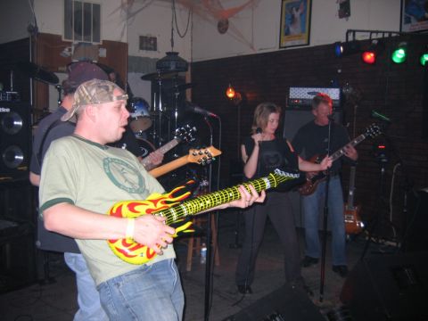 1977 Ford F-150 - A band plays music on a stage with multiple instruments and microphones.