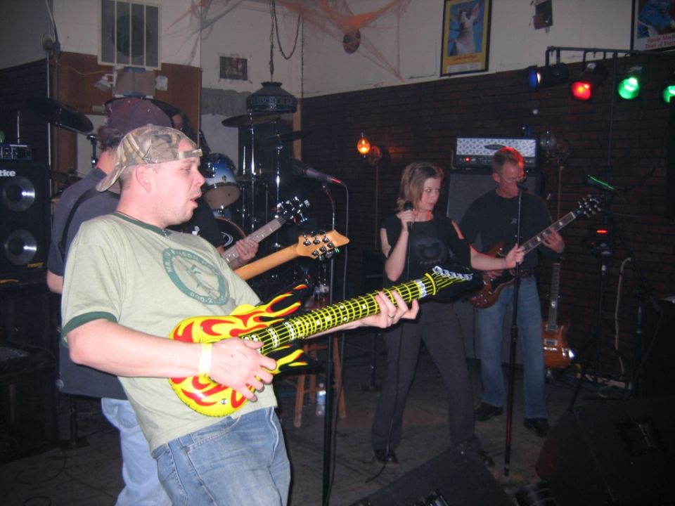 Band performing on stage with guitars and drums
