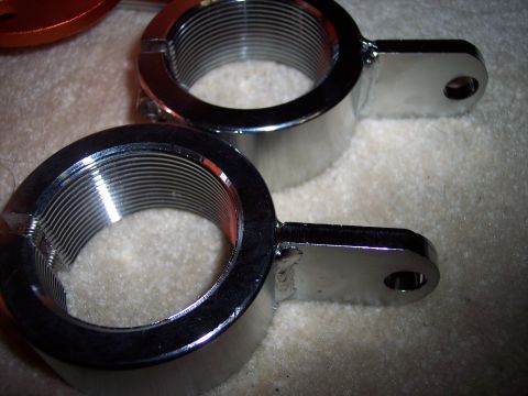 1995 Ford Probe - Close-up of two shiny chrome hose clamps, each with a threaded interior and a mounting bracket.
