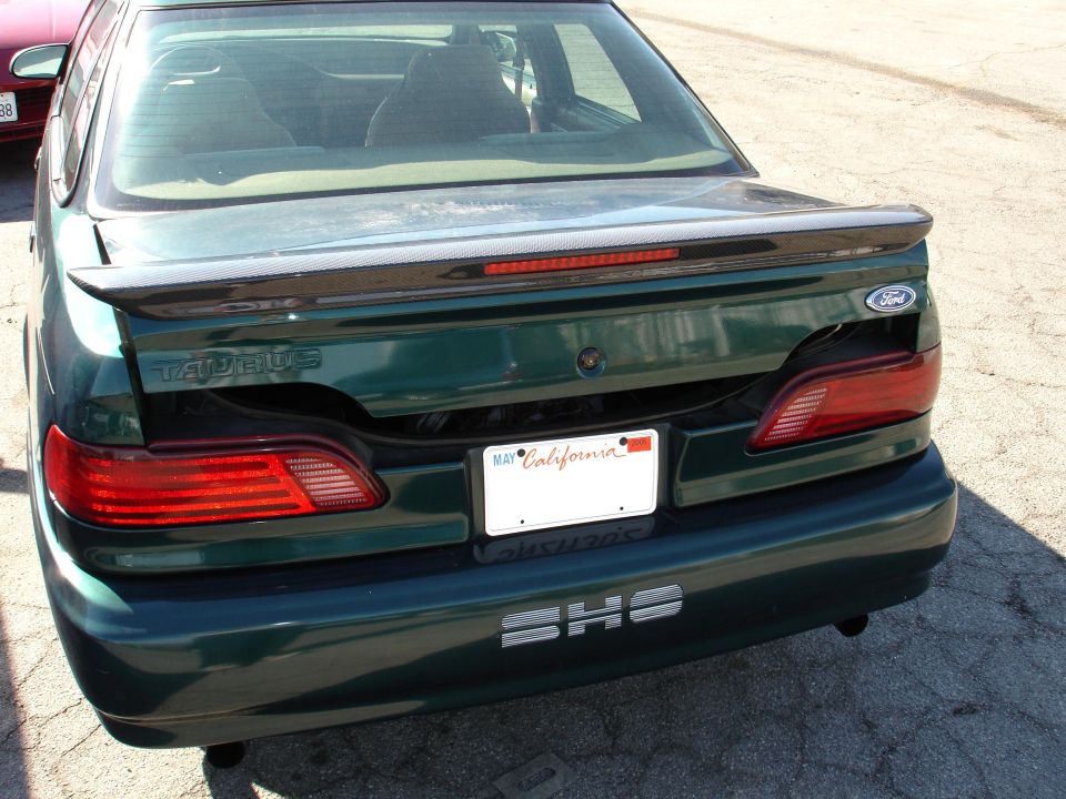 Green 1993 Ford Taurus sedan rear view with a carbon fiber spoiler and SHS badging