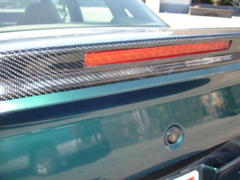 1993 Ford Taurus - Close-up of a rear spoiler carbon fiber accents and a red LED brake light strip.