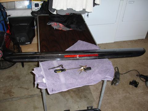 1993 Ford Taurus - Carbon fiber spoiler with integrated LED brake light, placed on a towel with a screwdriver and keys.