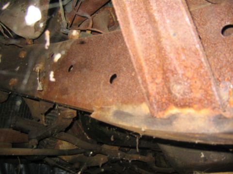 1956 Ford Thunderbird - The underside of a vehicle shows significant rust on the frame and suspension parts.