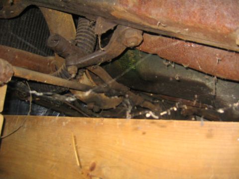 1956 Ford Thunderbird - The underside of a vehicle shows extensive rust and cobwebs, with wooden planks in the foreground.