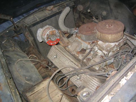 1956 Ford Thunderbird - Close-up of a V8 engine, likely from an older vehicle, with visible dual carburetors and air filters.