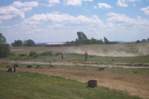 1979 Ford F-150 - A truck creates a dust cloud while driving on a dirt track, observed by two individuals in a rural setting.