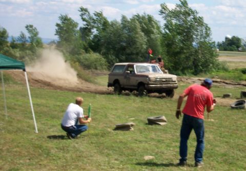 1979 Ford F-150 - A Ford Bronco navigates a dirt course, creating a cloud of dust as spectators observe the event.