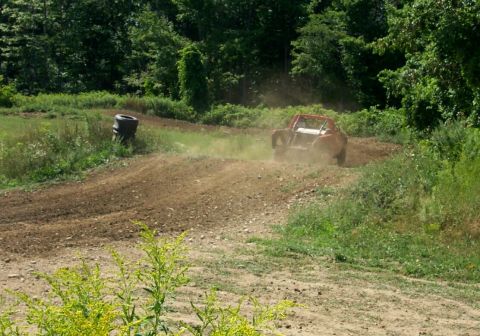 1979 Ford F-150 - A buggy races around a dirt track, leaving a trail of dust behind it.