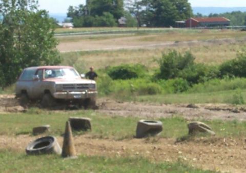 1979 Ford F-150 - A Dodge Ramcharger navigates a muddy off-road course, with tires and cones scattered around.