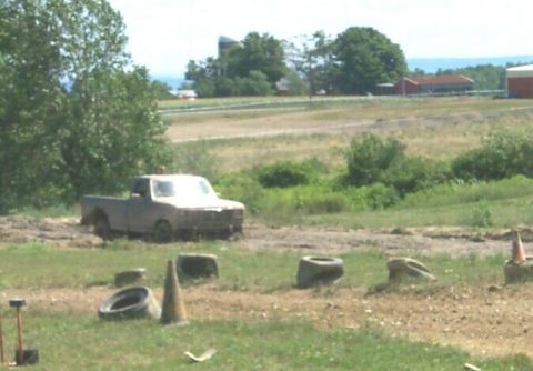 1979 Ford F-150 - A weathered pickup truck navigates a muddy track surrounded by obstacles.
