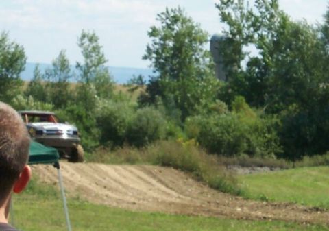 1979 Ford F-150 - A modified truck navigates an off-road course with a silo visible in the distance.