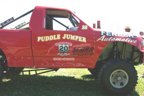 1979 Ford F-150 - This modified truck, labeled 'Puddle Jumper', features extensive racing decals and appears to be set up for off-road use.
