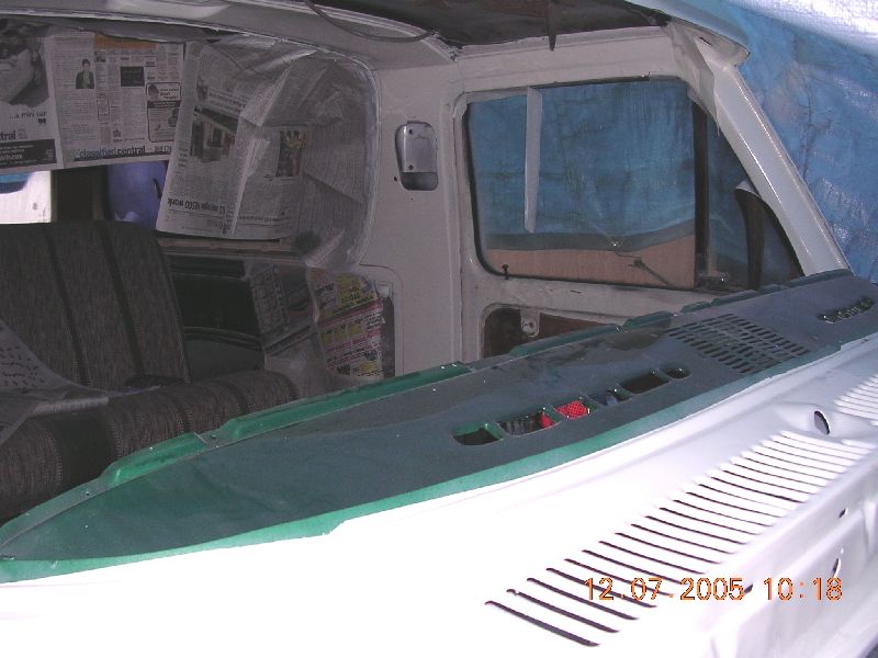 Vehicle interior with newspaper covering windows and seats, green dashboard visible