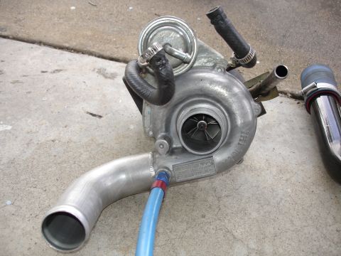 1989 Mazda MX-6 - A turbocharger is shown, a component used to increase engine power by forcing more air into the combustion chamber.