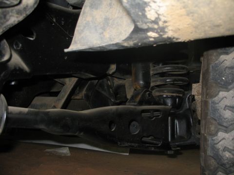 1981 Ford Bronco - Undercarriage view of a vehicle's suspension system, showing a control arm and shock absorber.
