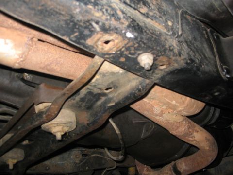 1981 Ford Bronco - Close-up of the underbody, showing rust on exhaust and frame parts.