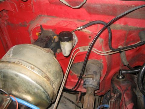 1981 Ford Bronco - The brake master cylinder and booster are visible in the engine compartment, connected by hoses and wires.