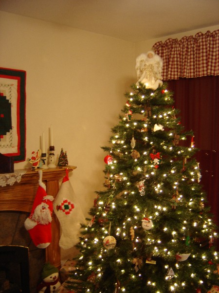 1999 Ford Taurus - A decorated Christmas tree stands next to a fireplace adorned with festive stockings and ornaments.