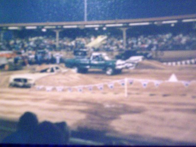 1972 Ford Ranchero - Dirt track event with multiple vehicles and crowd in the stands.
