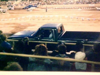 1972 Ford Ranchero - A pickup truck drives on a dirt track during an event, with spectators in the foreground.