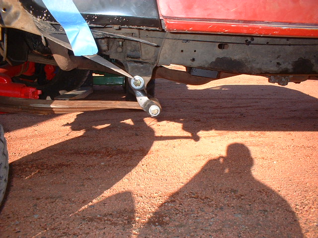 Red truck frame and suspension with blue tape on body panel