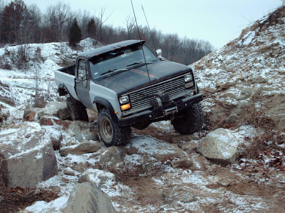 Pickup truck navigating a rocky, snowy trail. It has a winch mounted on the front bumper