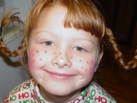1986 Ford Bronco - A young girl with braided pigtails and drawn-on freckles smiles for the camera, wearing a festive holiday shirt.