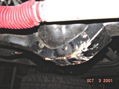 1990 Ford Bronco - Underside view of vehicle differential and suspension components with a red hose visible.