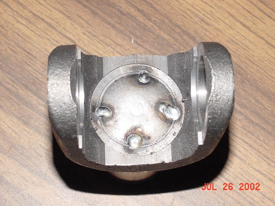 Steel axle slip-joint yoke with a round cap tack-welded in place at four spots