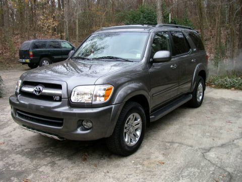 1995 Ford Bronco - A gray 2006 Toyota Sequoia is parked on a concrete driveway, with another SUV visible behind it.