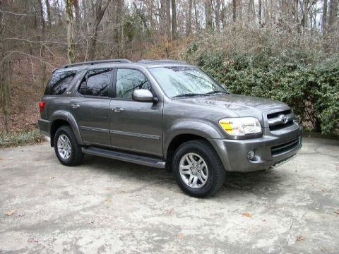 1995 Ford Bronco - This SUV is parked outdoors on a paved surface, surrounded by trees and bushes.
