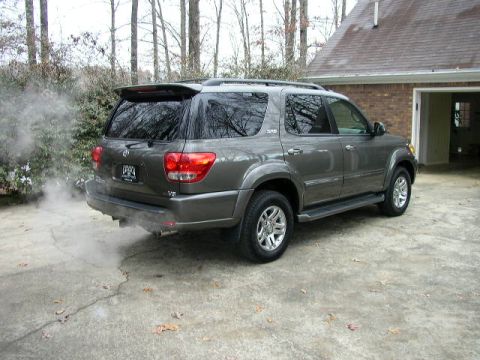 1995 Ford Bronco - Gray 2006 Toyota Sequoia seen from the rear 3/4 angle, emitting exhaust smoke.