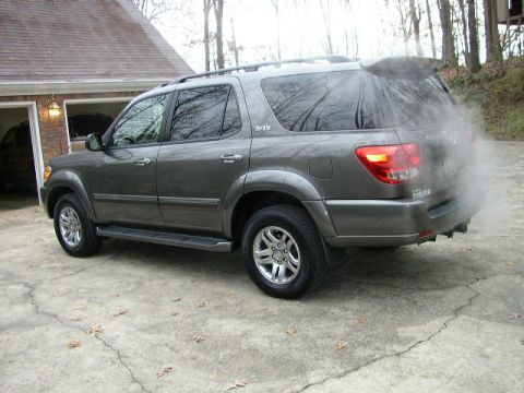1995 Ford Bronco - Gray Toyota Sequoia parked on concrete driveway, emitting exhaust smoke from the rear.