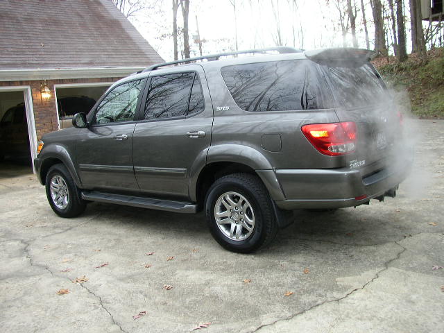 Gray Toyota Sequoia parked on concrete driveway, emitting exhaust smoke from the rear