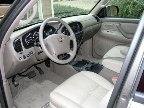 1995 Ford Bronco - The interior of a Toyota Tundra features light-colored leather seats and a beige dashboard with a prominent Toyota emblem on the steering w…