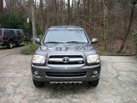 1995 Ford Bronco - The front view of a gray Toyota Sequoia is shown, with a dark SUV parked in the background.