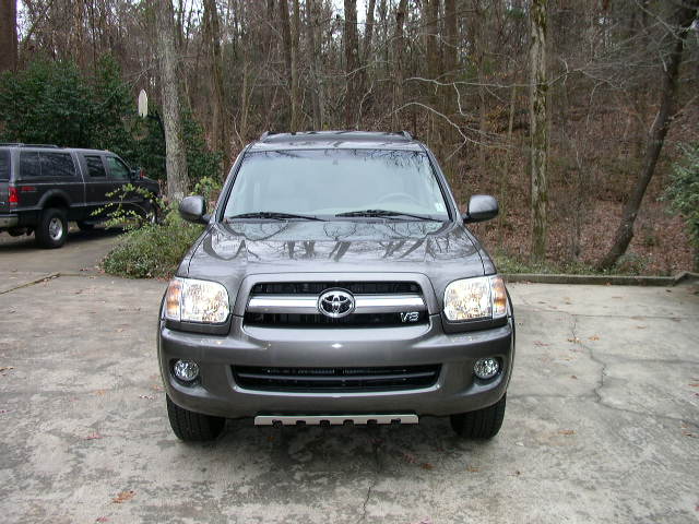 Gray Toyota Sequoia parked in driveway, dark SUV in background