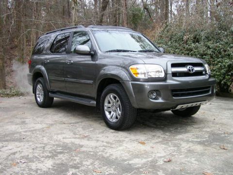 1995 Ford Bronco - This gray Toyota Sequoia SUV is shown from a three-quarter front view on a paved surface with foliage behind it.