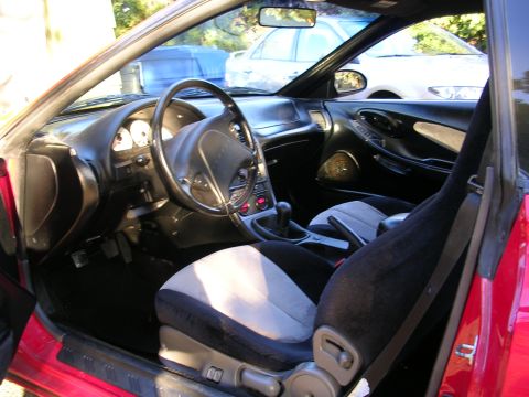 1996 Ford Probe - The interior of a red car is visible, the dashboard, steering wheel, and two-tone seats.