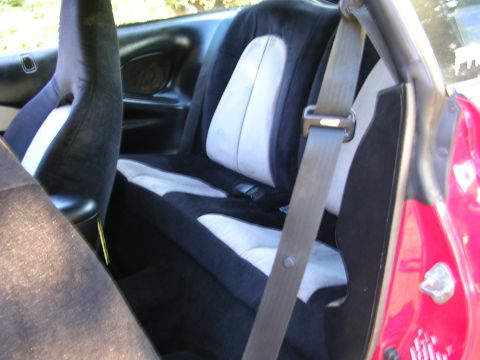 1996 Ford Probe - The rear seats of a car are shown, a two-tone upholstery design and a visible seatbelt mechanism.