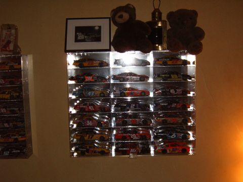 1993 Ford Bronco - Multiple shelves hold a large collection of NASCAR diecast model cars, each displayed individually.