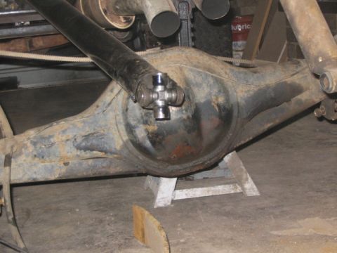 1981 Ford Bronco - Close-up view of a vehicle's rear axle assembly and driveshaft, resting on jack stands.