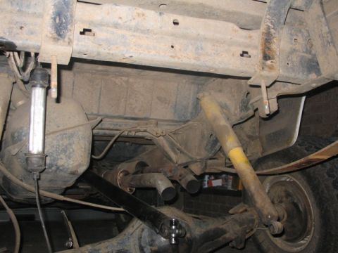 1981 Ford Bronco - Undercarriage of a vehicle, focusing on the rear suspension and dual exhaust system.